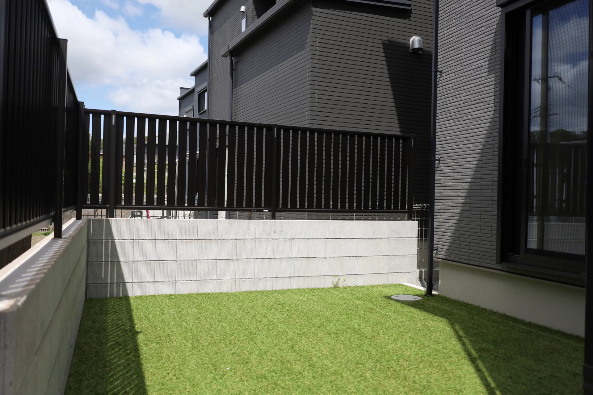 フェンスで囲んだプライベートな人工芝の庭